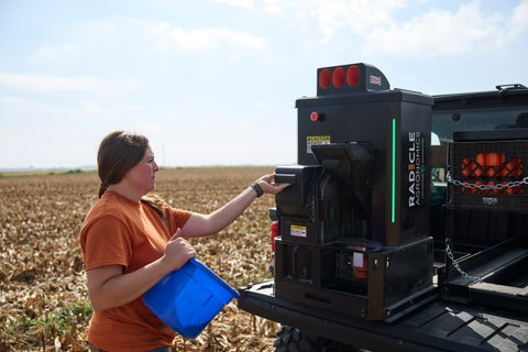 A farmer opens the GeoPress, mounted on a UTV, to load it with soil cores.