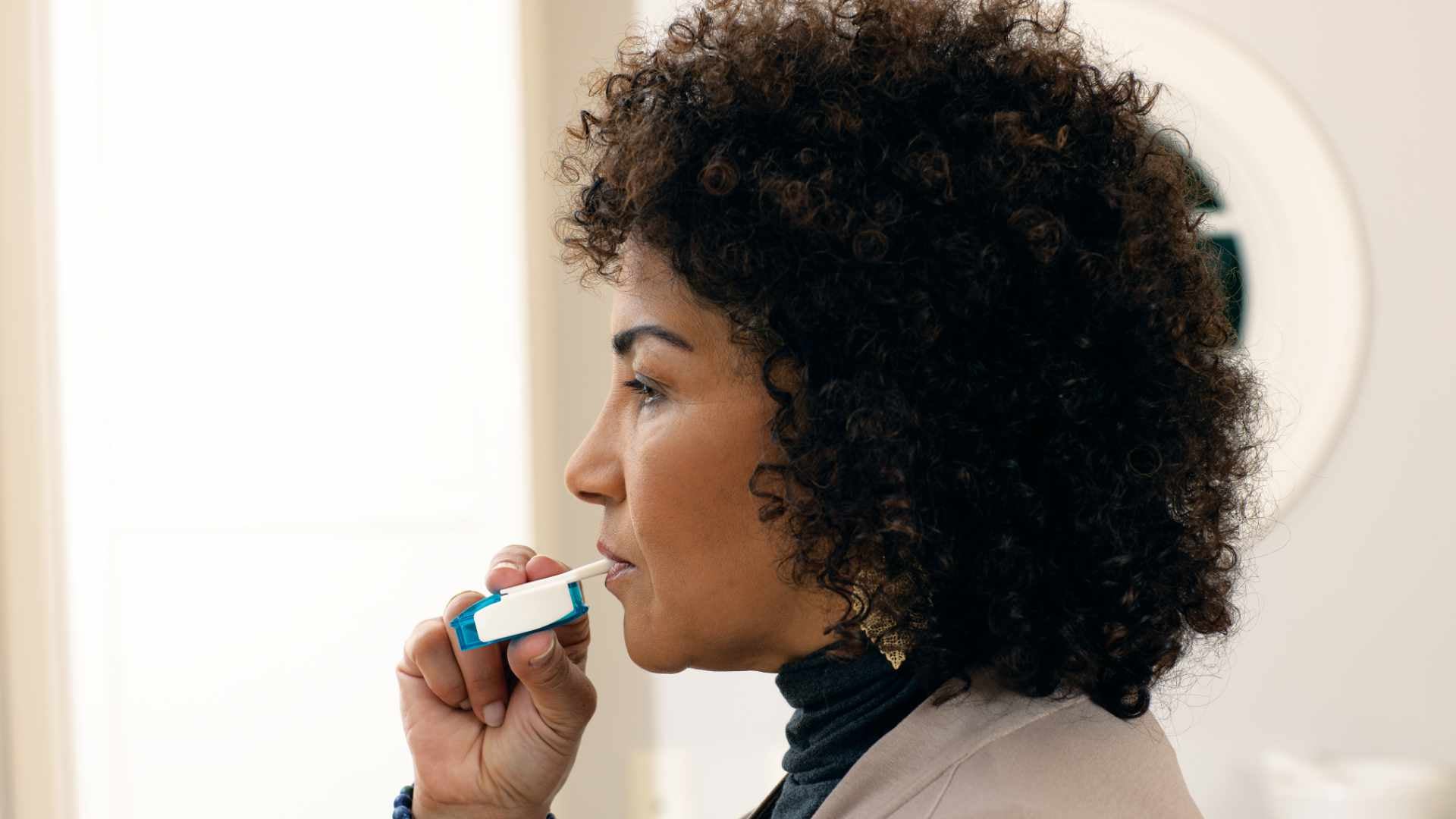 Photo of a woman using the Tyvaso inhalation system