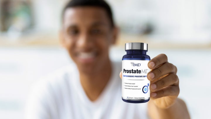 man showing a bottle of 1MD Nutrition's ProstateMD