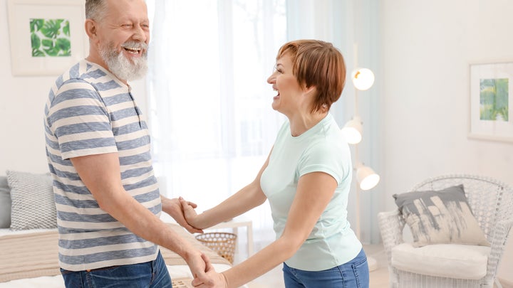 a senior couple dancing at home