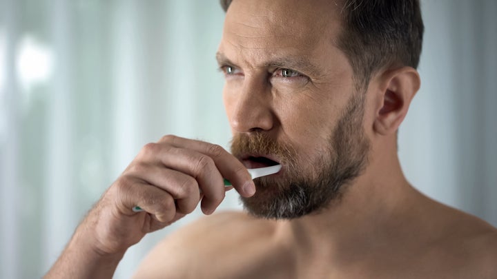 man brushing his teeth in the morning