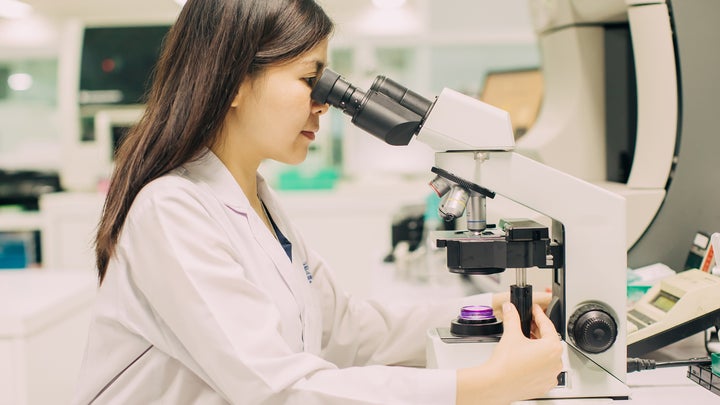 female scientist looking into a microscope