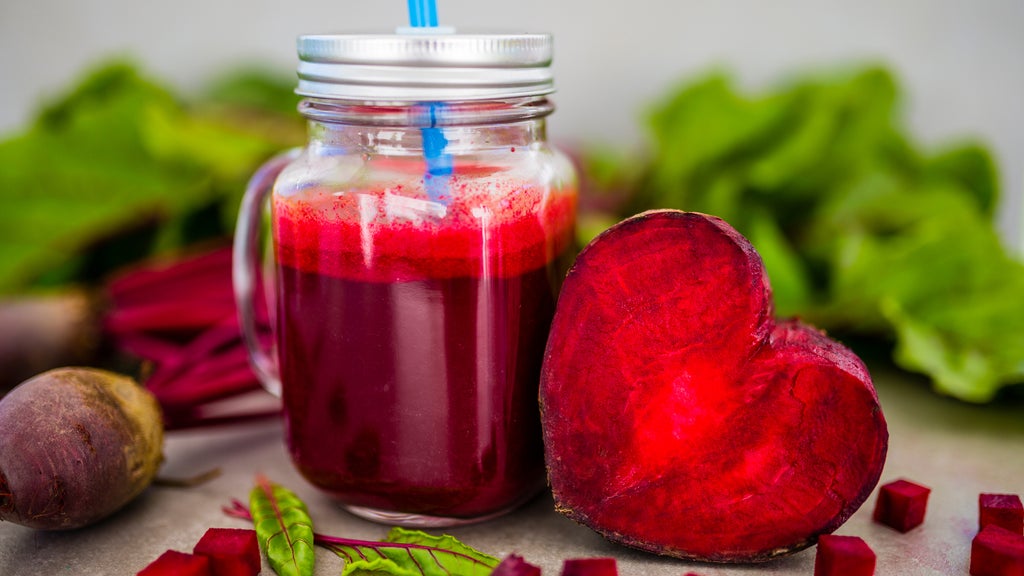 a beet cut in half and beet juice in a mason jar