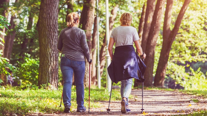 two women nordic walking in a city park