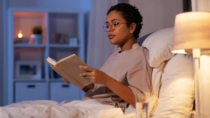 woman respecting her night time routine and reading a book in her bed