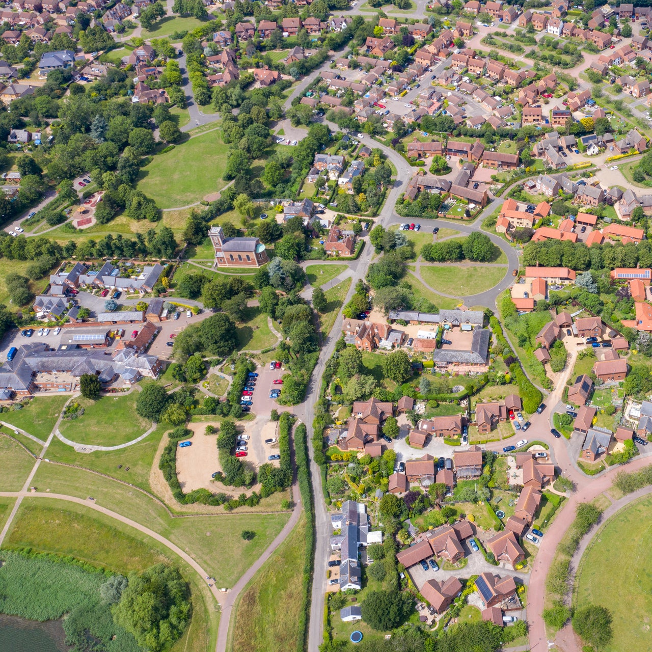 An aerial photo of a residential area with numerous houses and green spaces around.