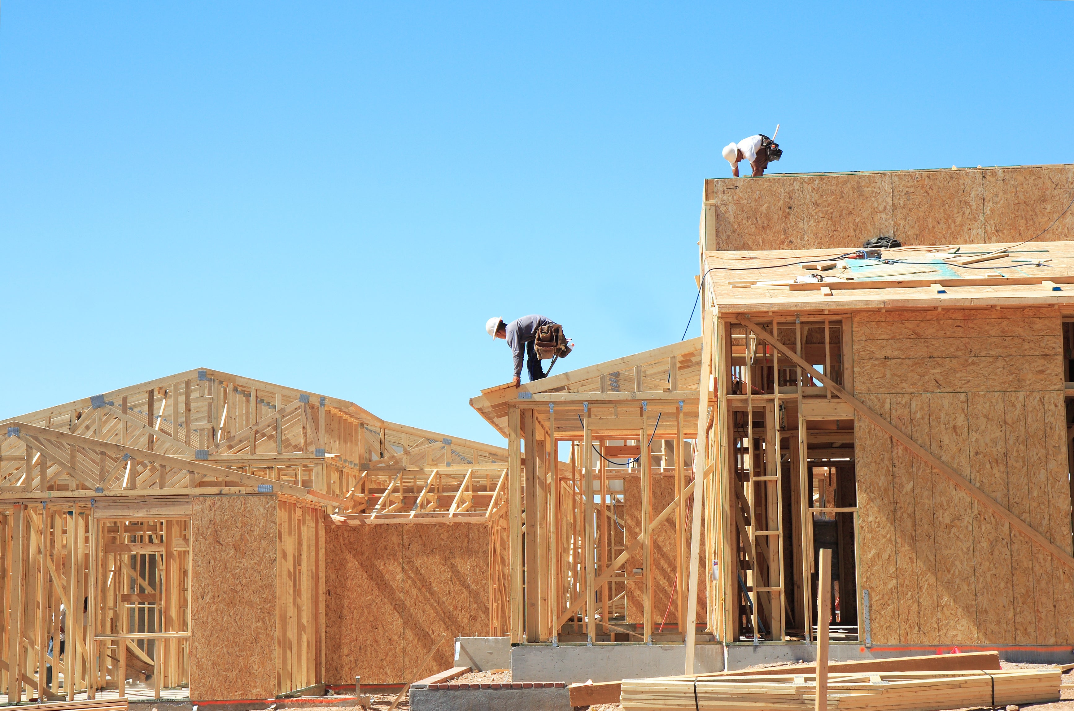 Builders on top of the roof of new contstruction