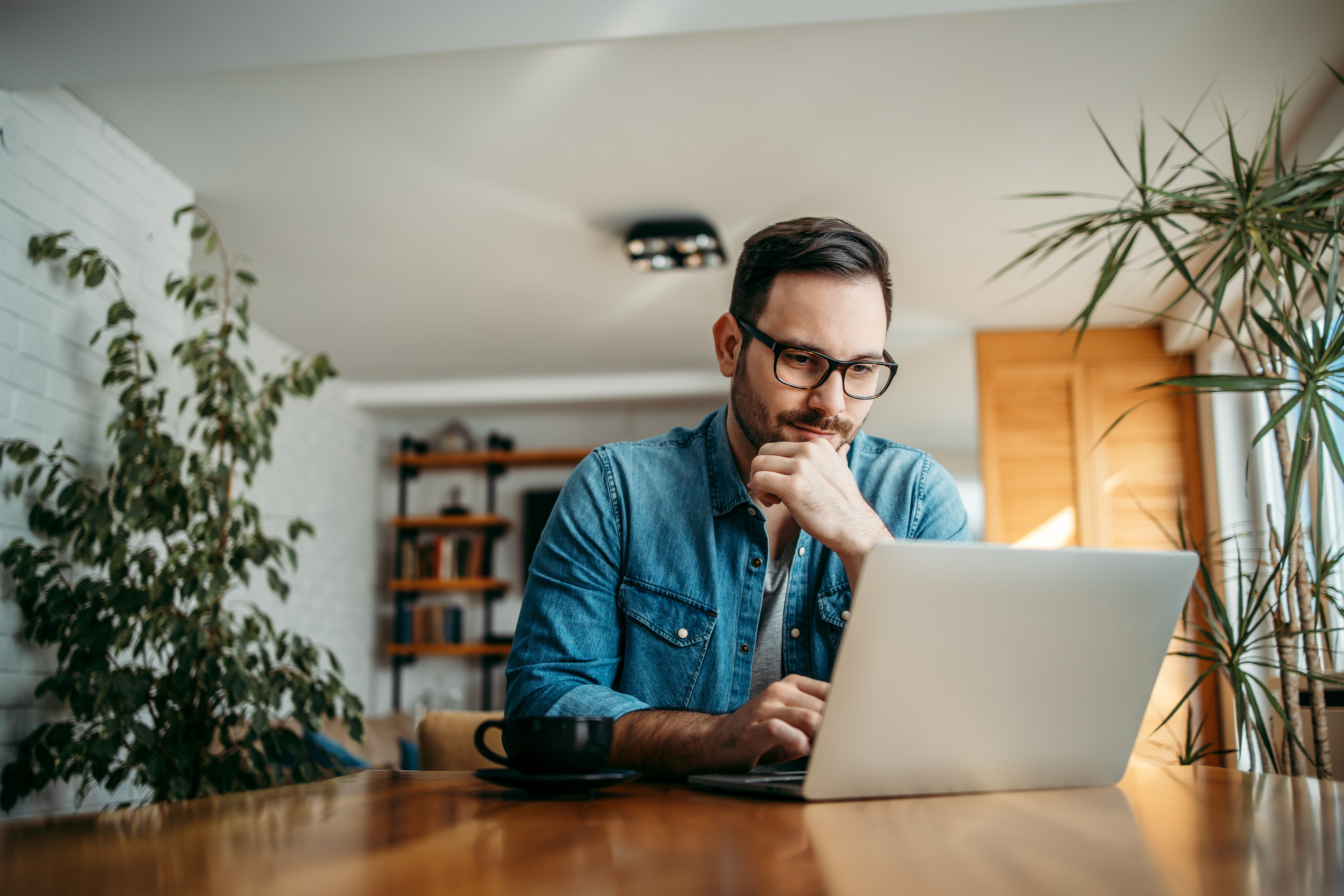 A man is seen looking into his laptop screen.