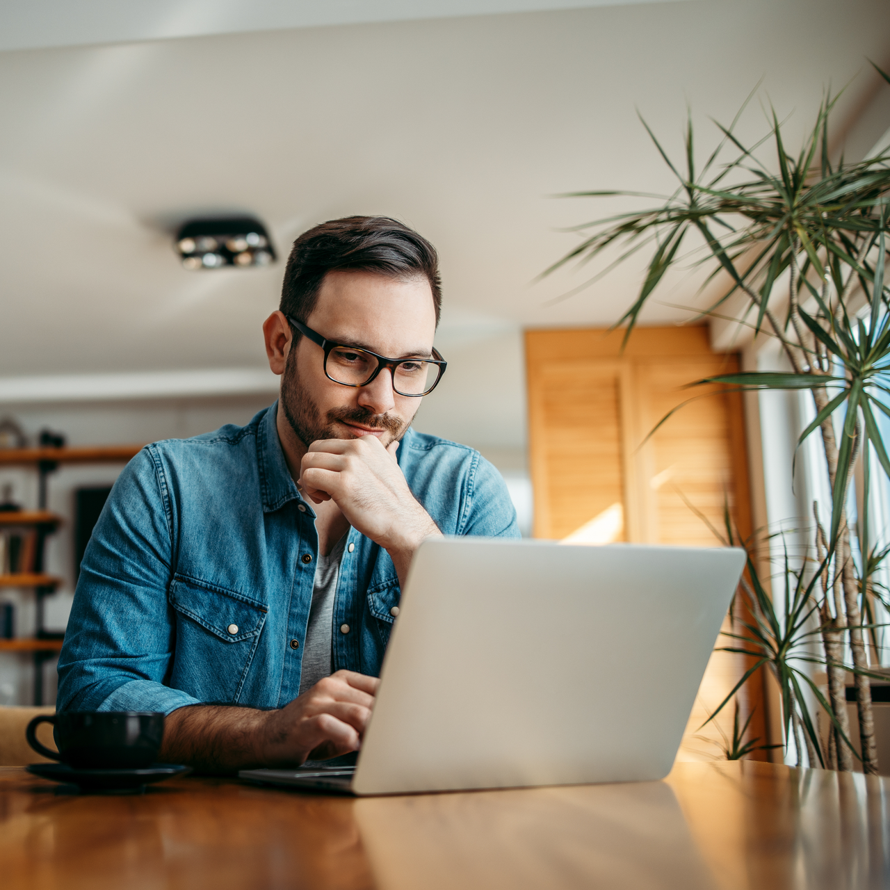 A man is seen looking into his laptop screen.