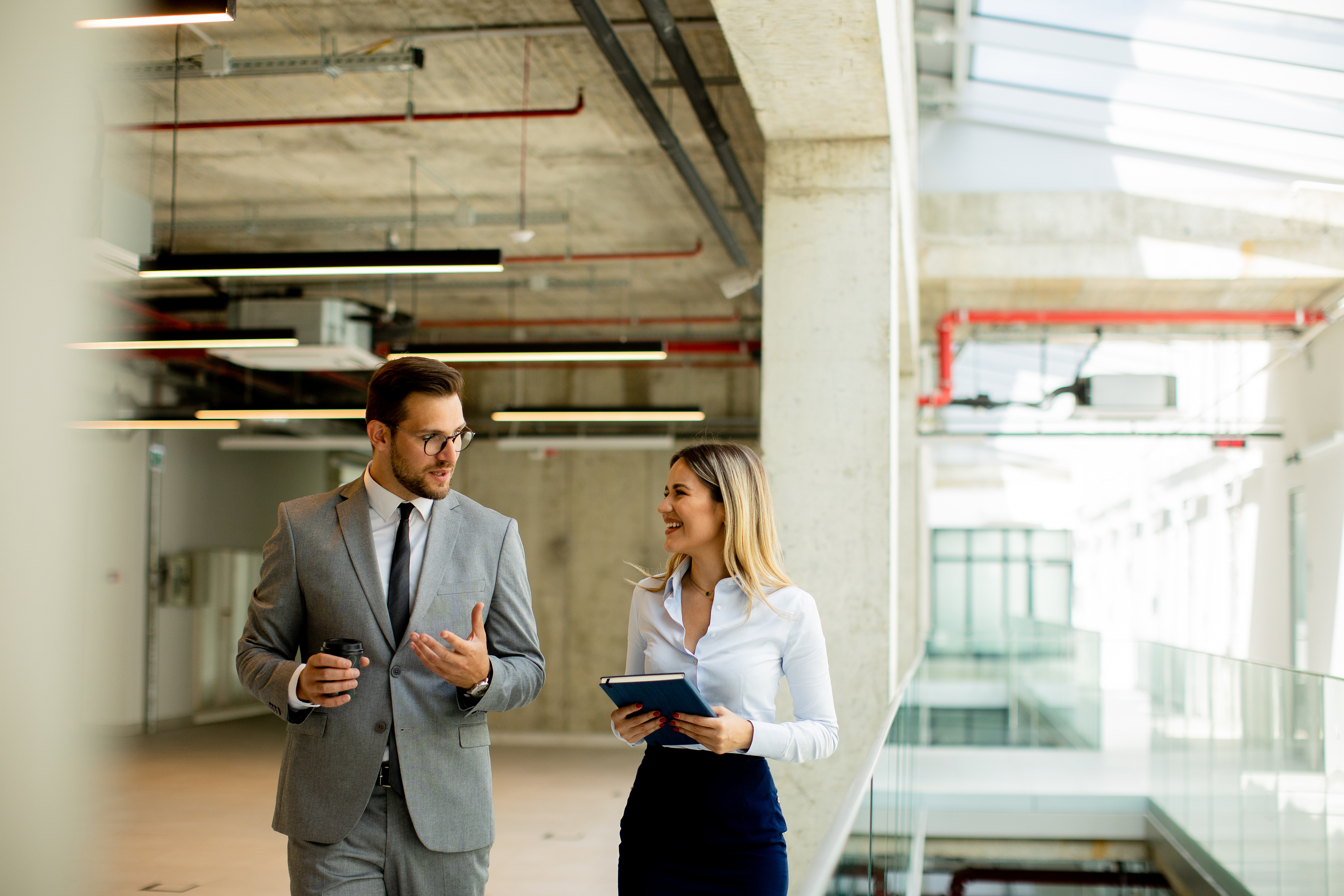 Two commercial real estate brokers reviewing details while touring a potential office space.