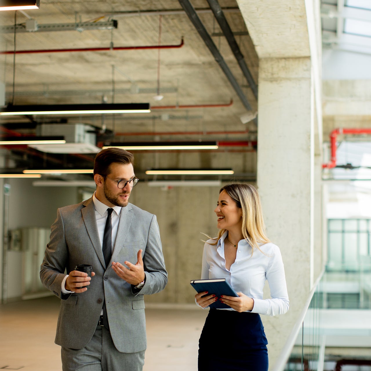 Two commercial real estate brokers reviewing details while touring a potential office space.