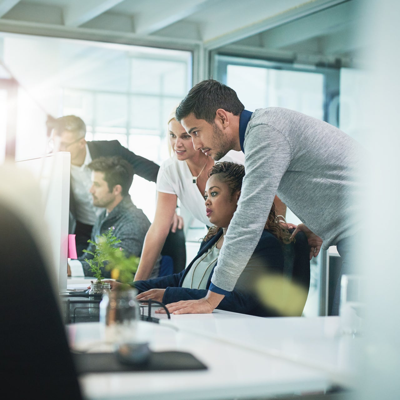 A corporate office set up with people working together. They are looking at computer screens.