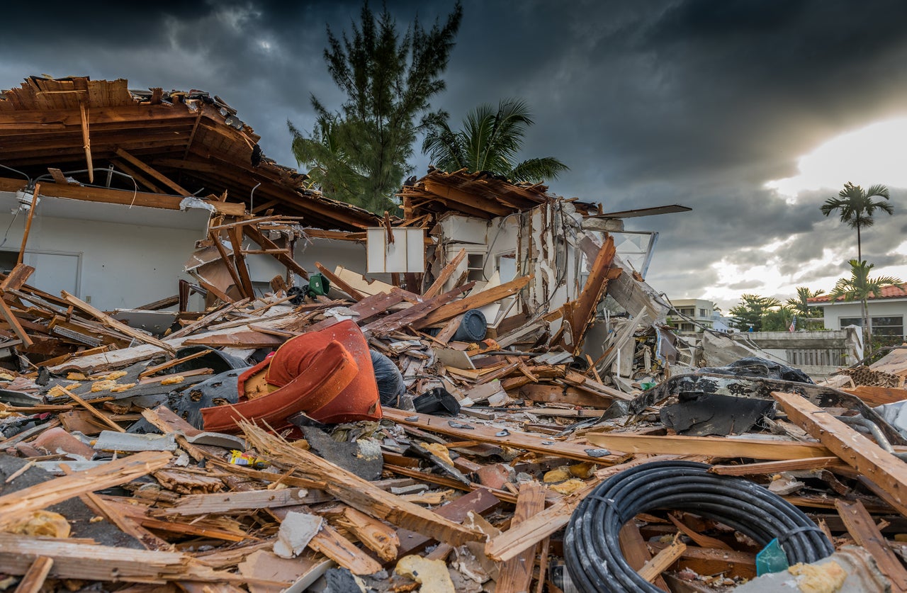 Destroyed house under palm trees after a hurricane
