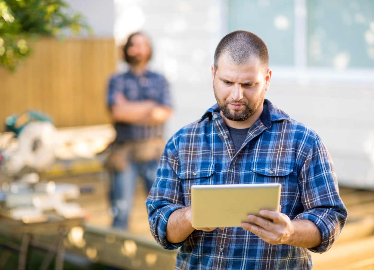 A man is seen working on a tablet.