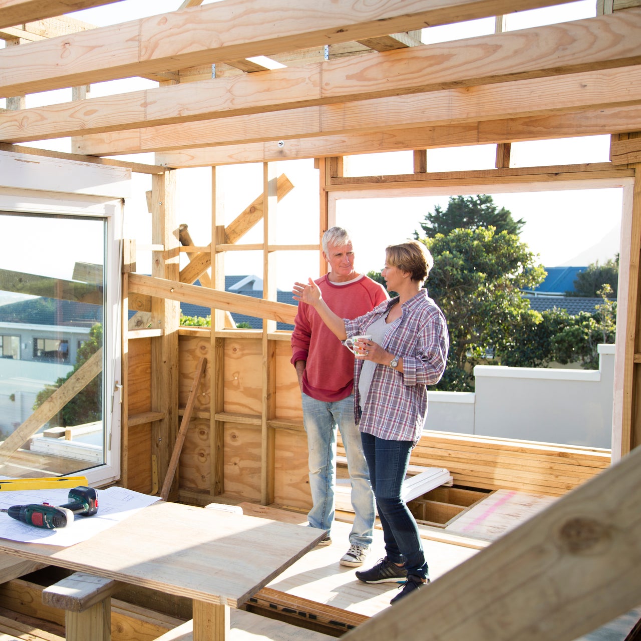 Un homme et une femme, peut-être un couple, qui discutent dans leur maison en construction.