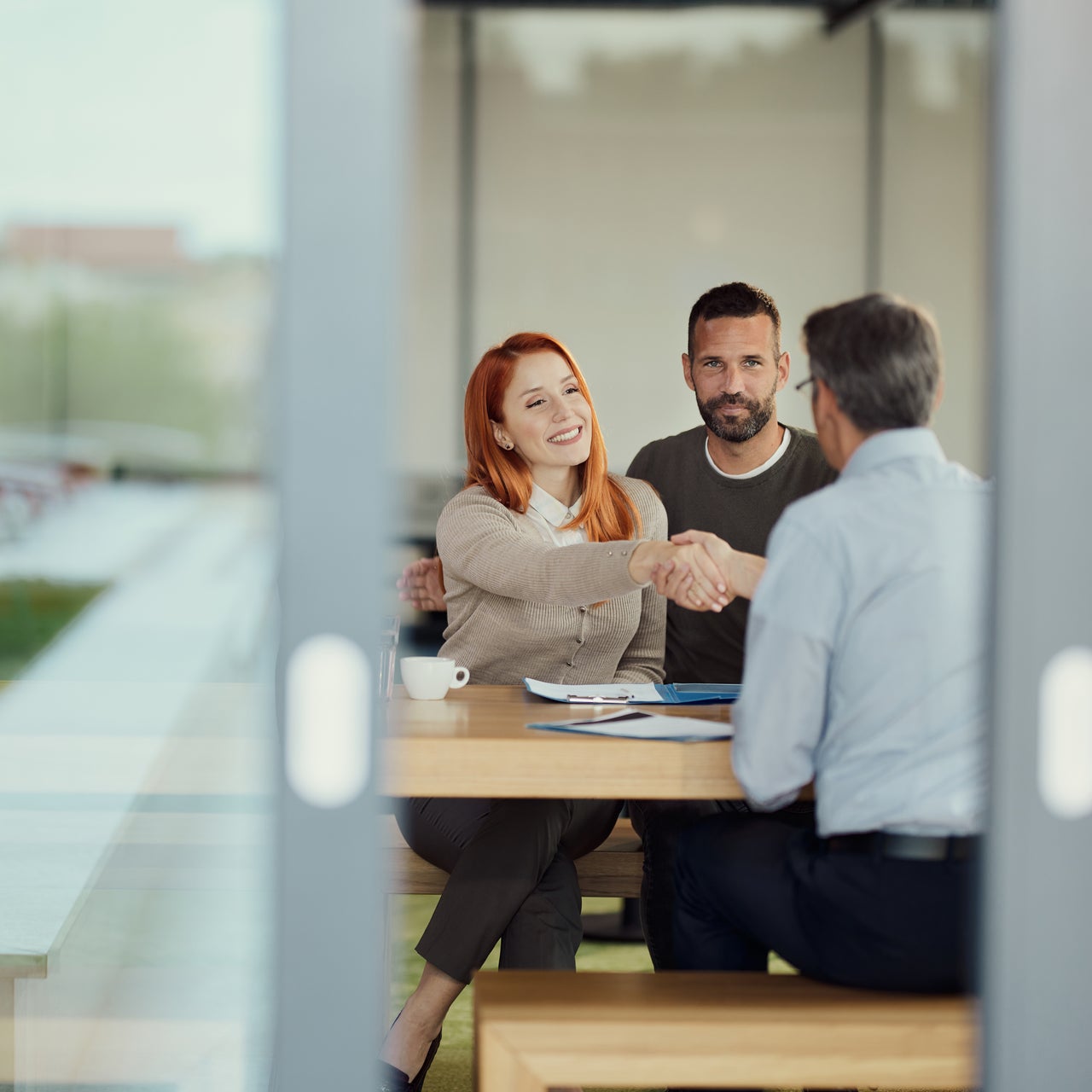 A couple sitting across the table with a real estate agent.