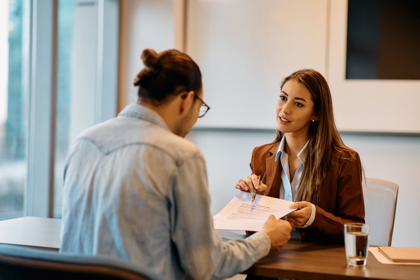 Real estate agent showing a homebuyer a paper to sign.