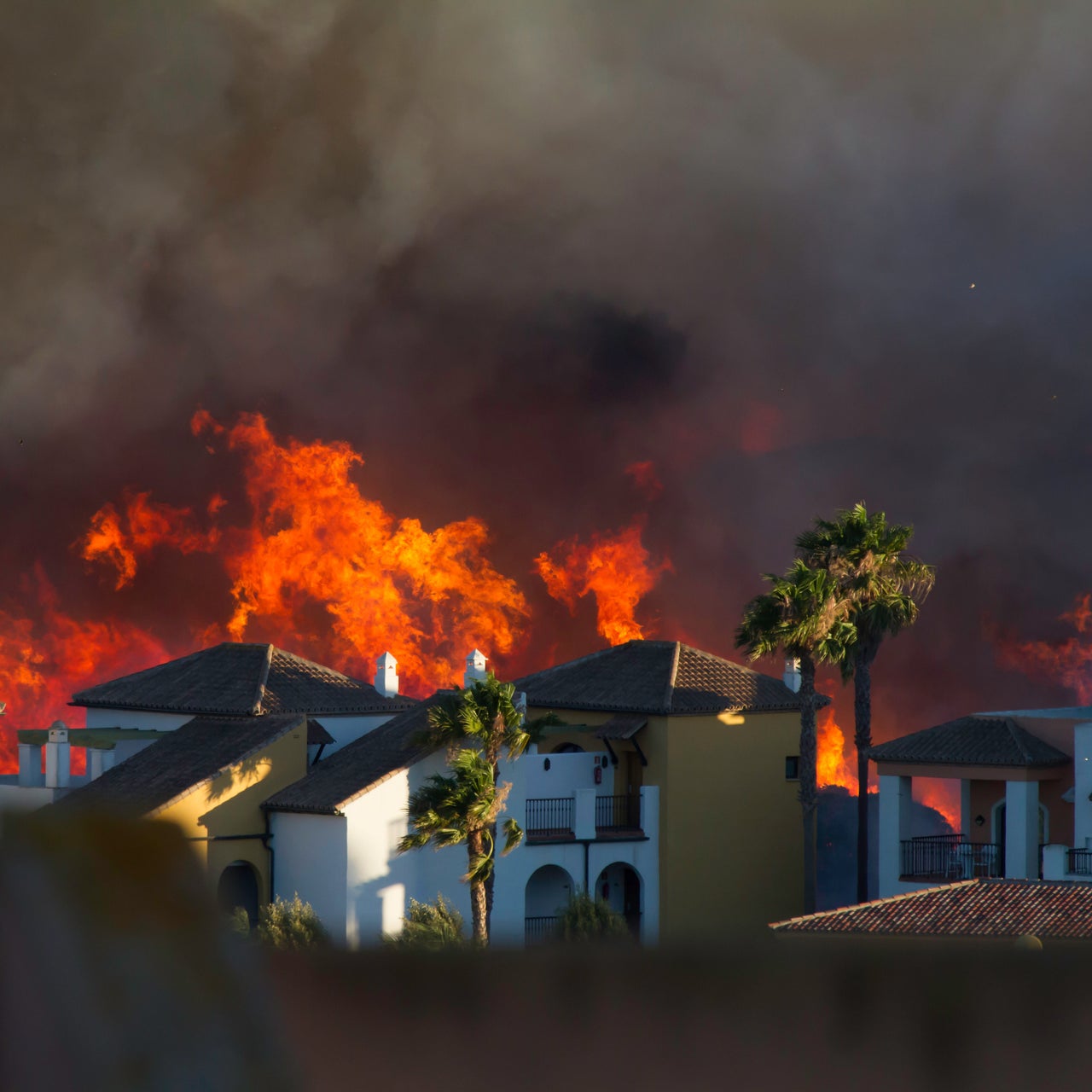 Wildfire close to houses being fought with airplanes and helicopters