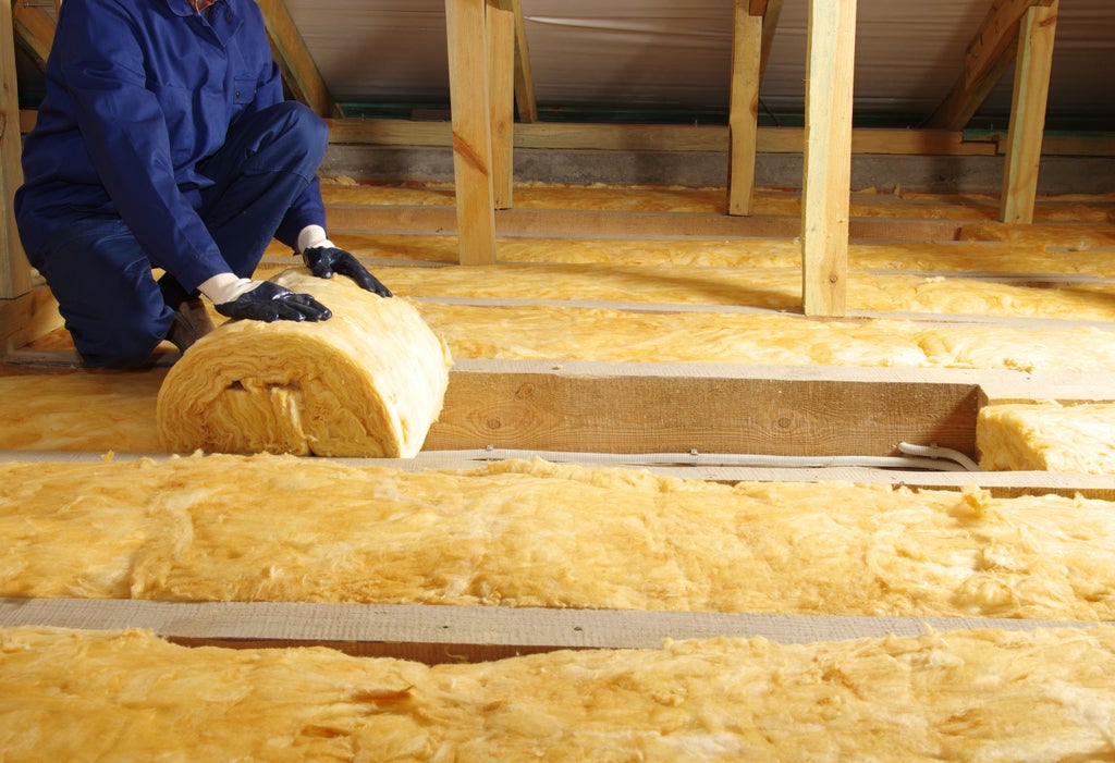 Contractor rolling out loft insulation