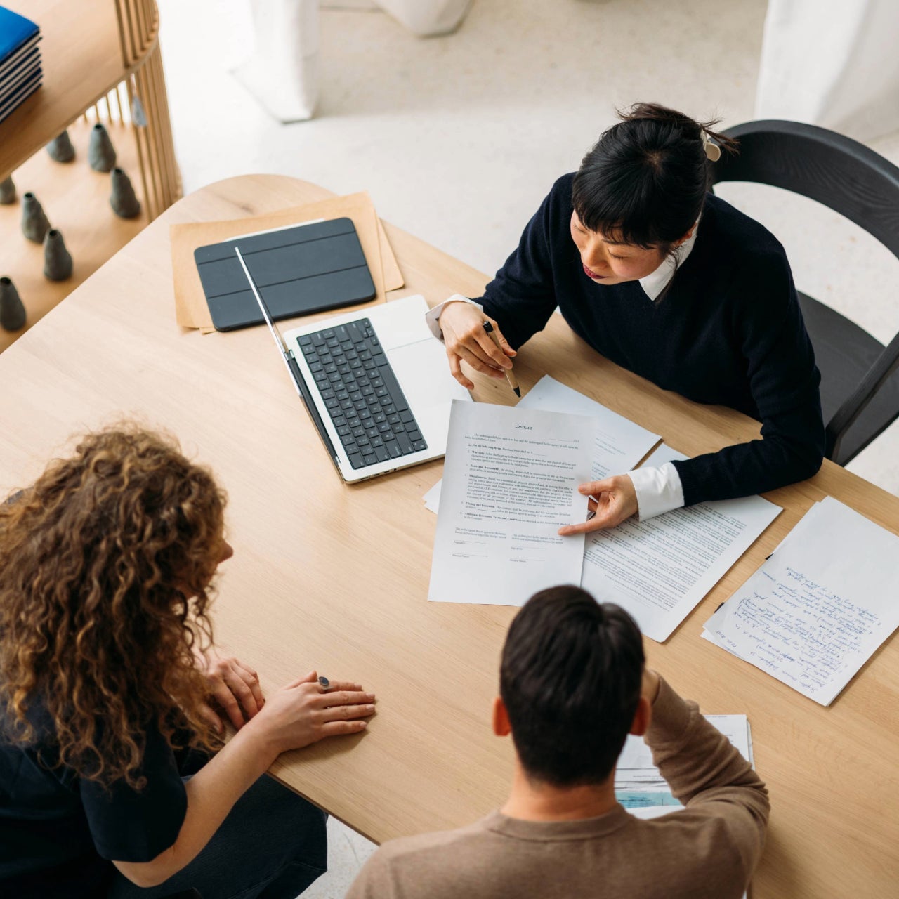 An overhead image of a real estate agent presenting to home sellers