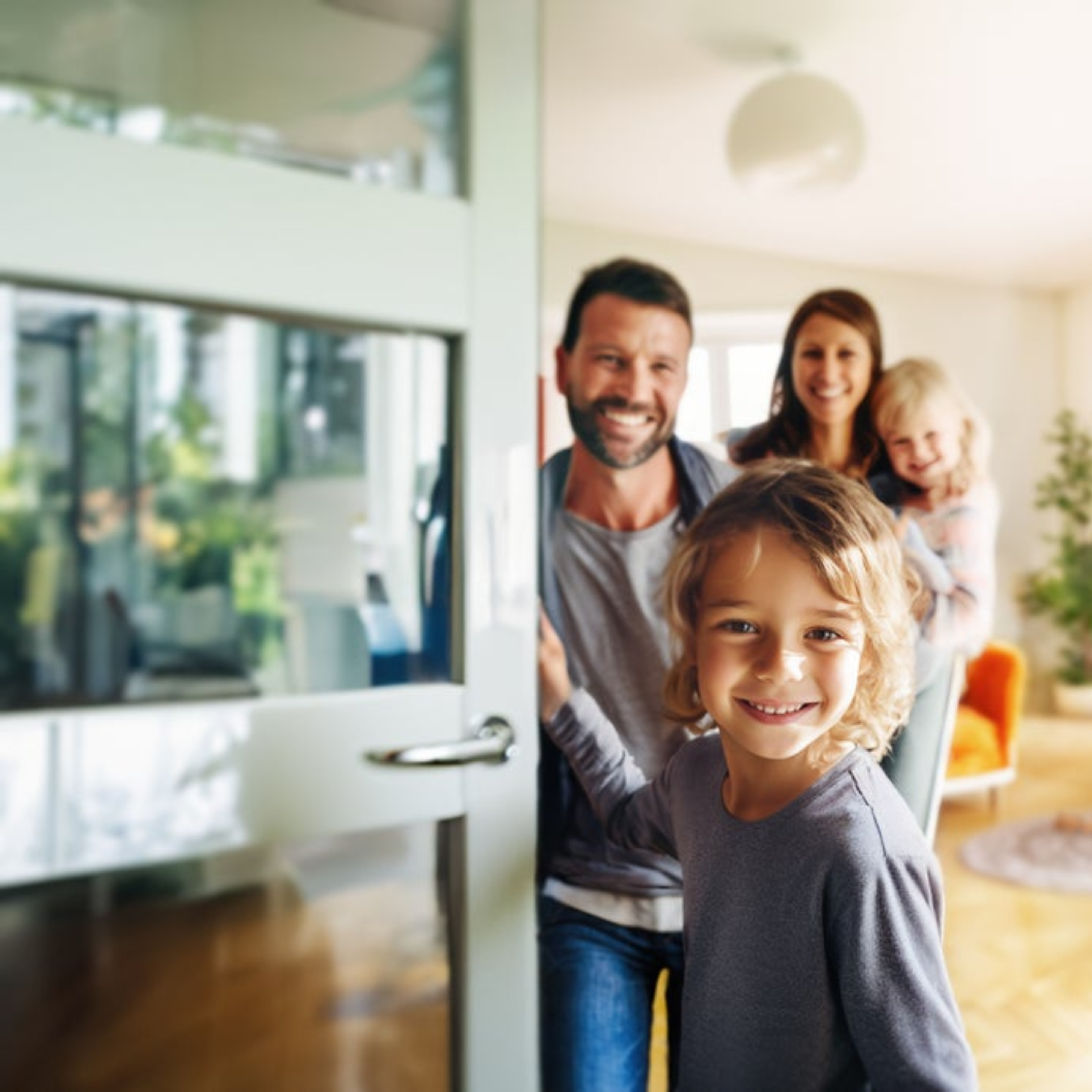 A smiling family with two young children opening the door to their new home, illustrating a successful milestone in the homeowner journey supported by a credit union mortgage. This image represents the purchase market growth and member experience possible through Cotality's integrated lending solutions.