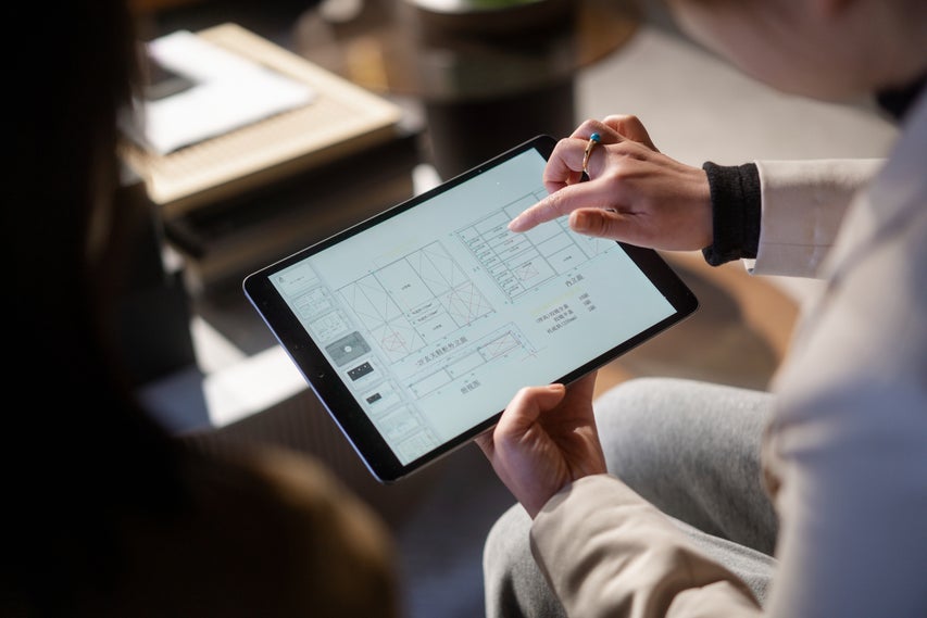 Real estate agent looking at closet plans on tablet.
