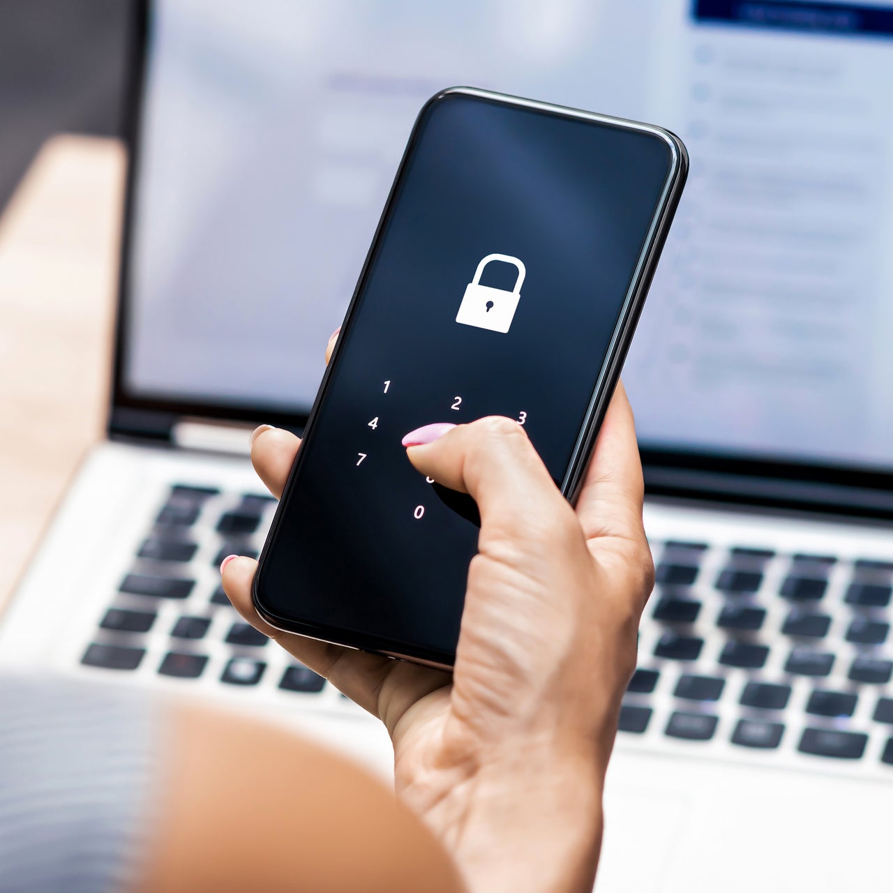 A real estate agent using multi factor authentication on his phone to connect to his laptop.