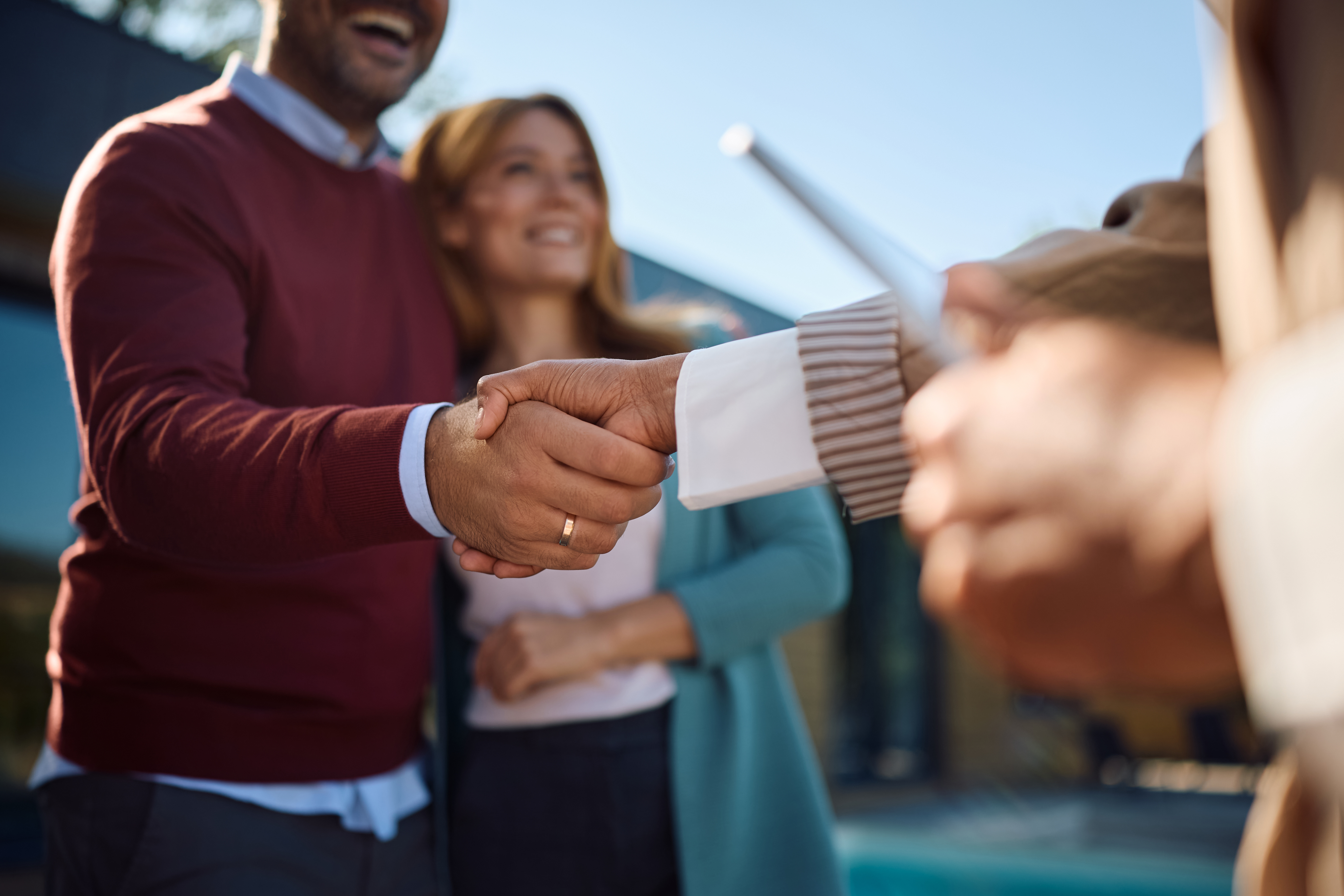 new buyers shaking hands with a real estate agent