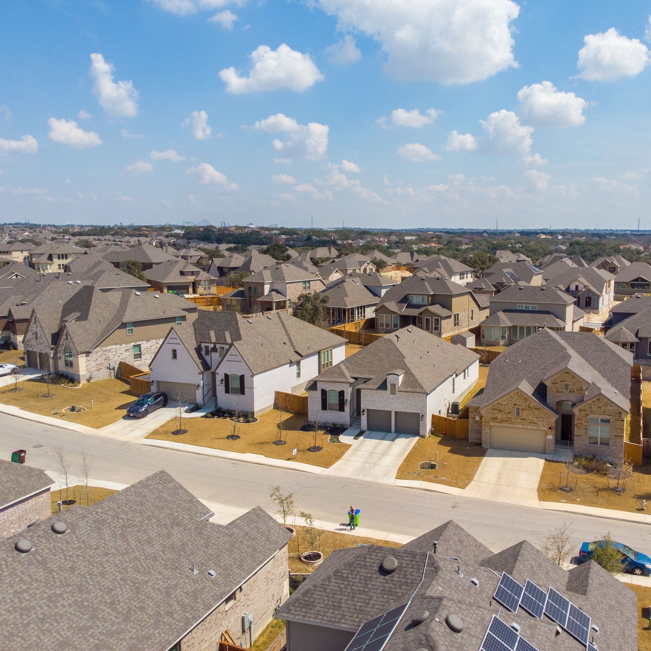 An aerial view of a suburban neighborhood, likely located in a warm climate due to the architectural style and landscaping.