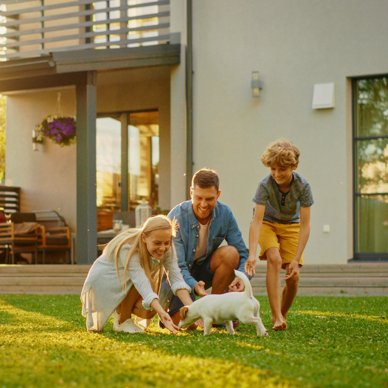 Group of people sitting around a table on an outdoor patio surrounded by lush greenery, enjoying a social afternoon..