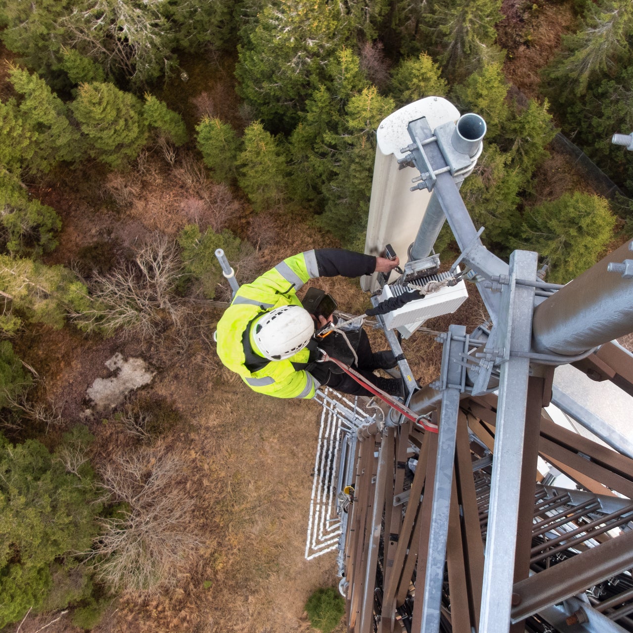 A worker climbing up a telecommunication tower to fix some glitch.