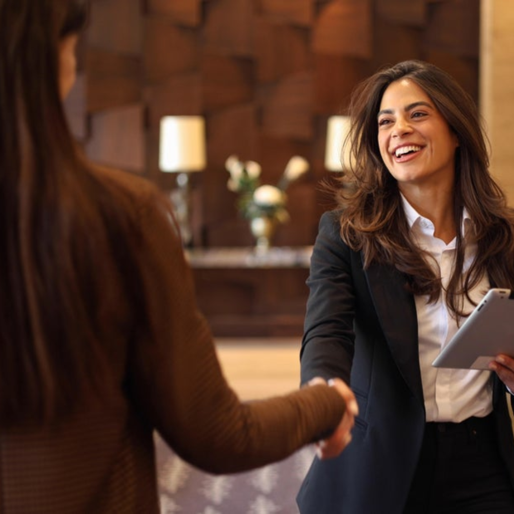 An image of a business woman greeting a customer.