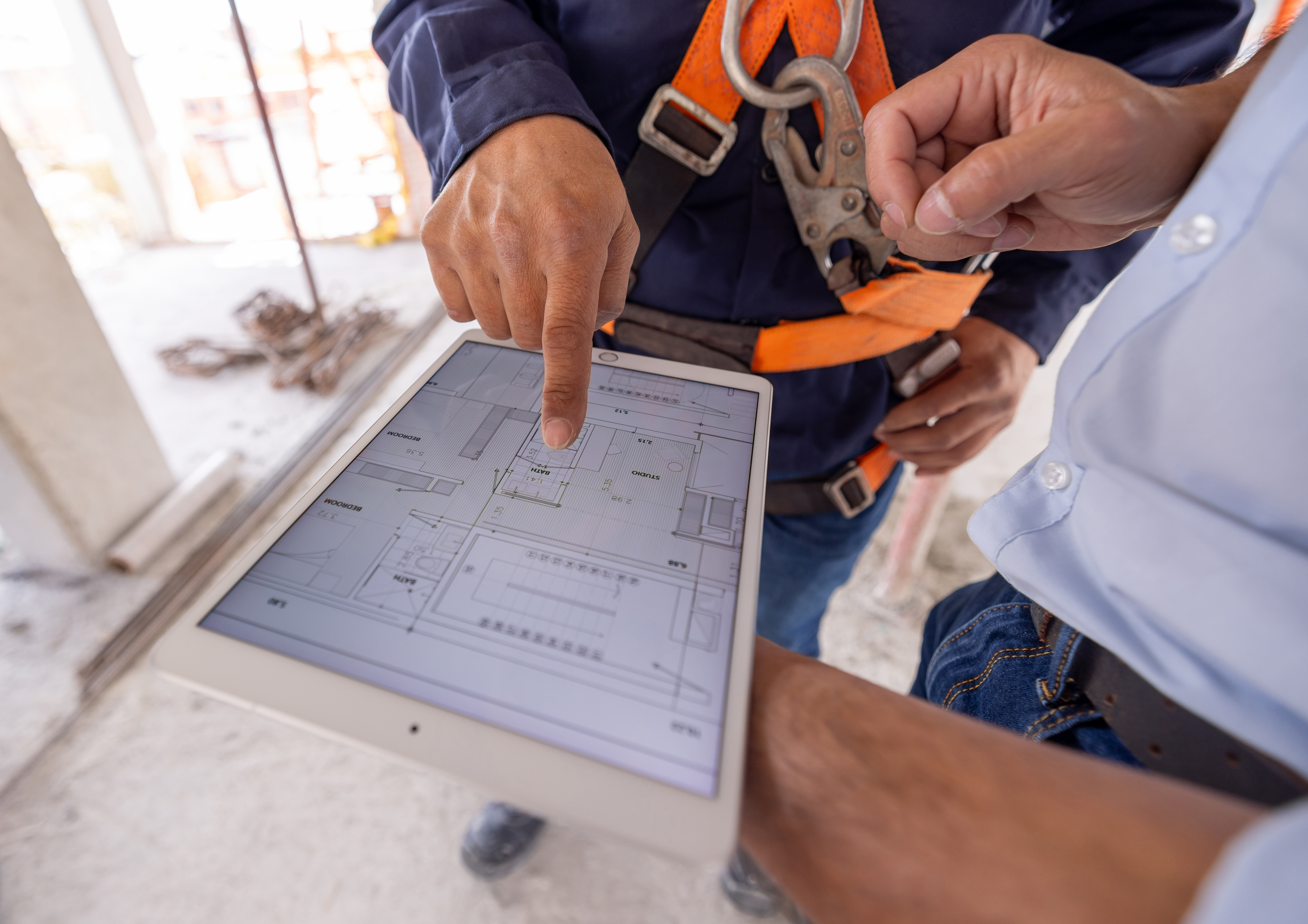 People interacting with a blueprint on a tablet