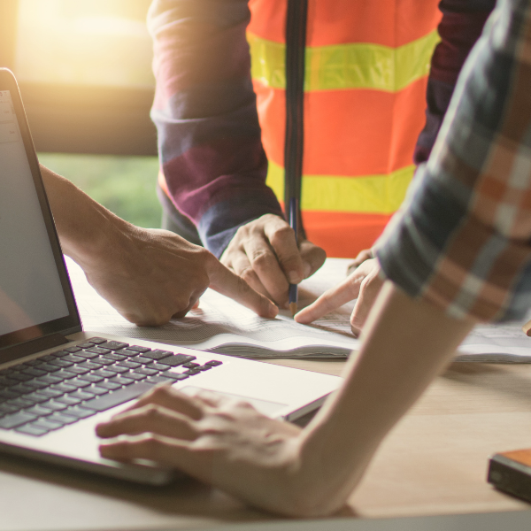 Three people in a meeting looking into documents kept on a table.