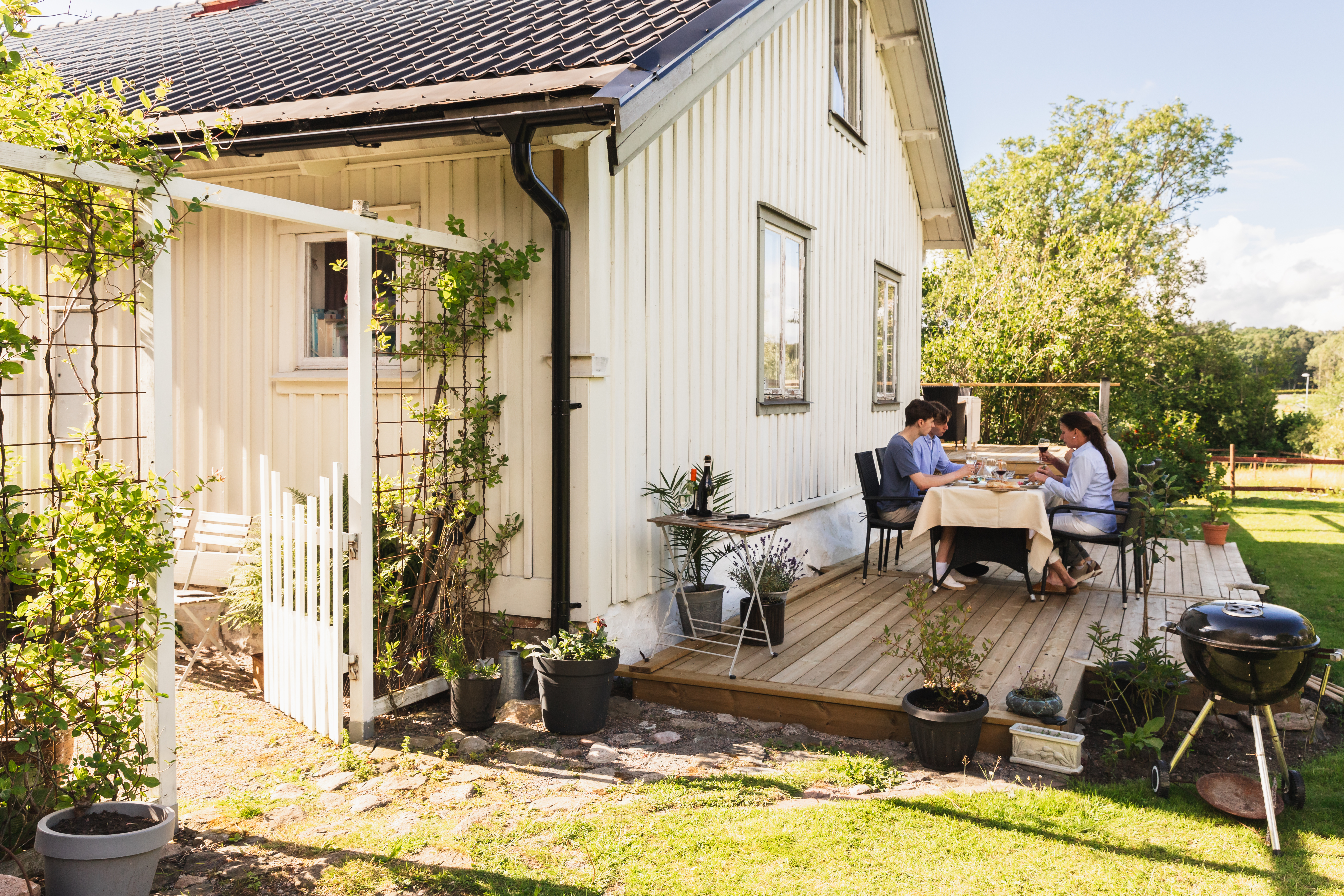 A family of four people, two children and their parents, spending time together in the outdoor area of their home.