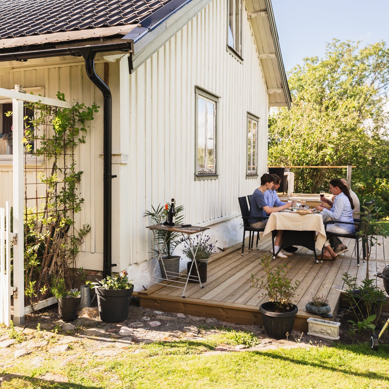 A family of four people, two children and their parents, spending time together in the outdoor area of their home.
