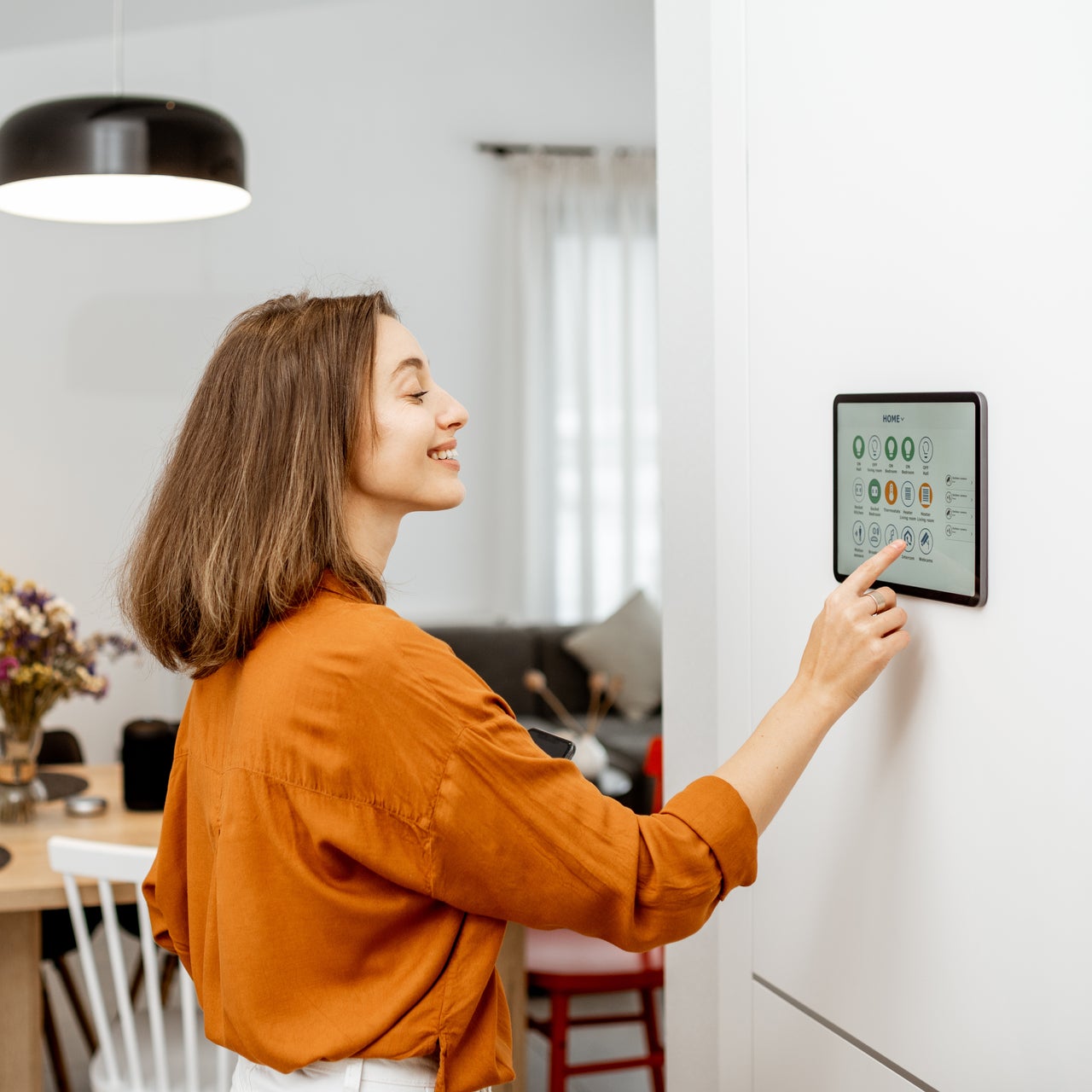 Row of houses on a hill with smoke rising in the background, indicating a possible wildfire hazard.