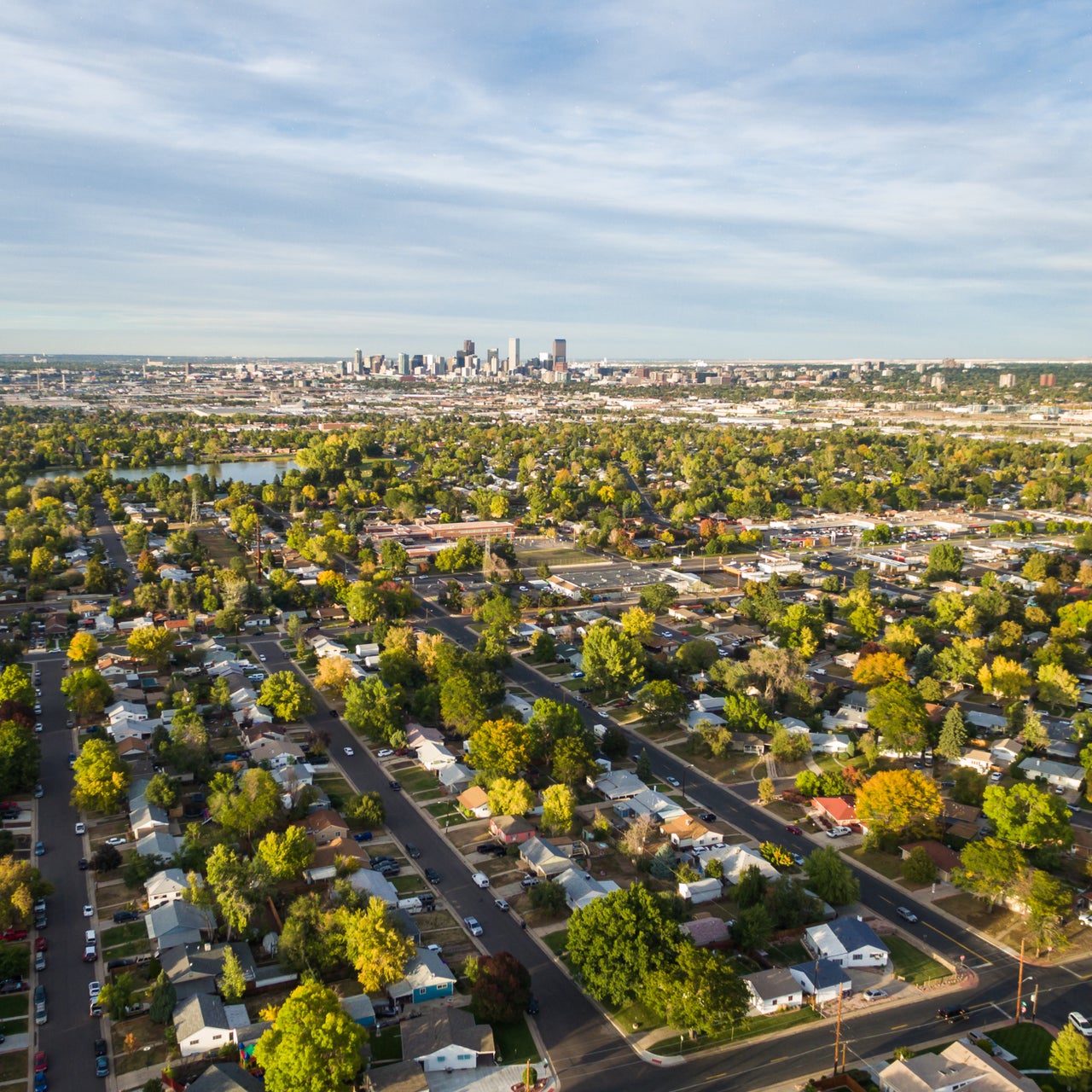 An aerial long shot of a residential area in close up and a commercial area in distance.