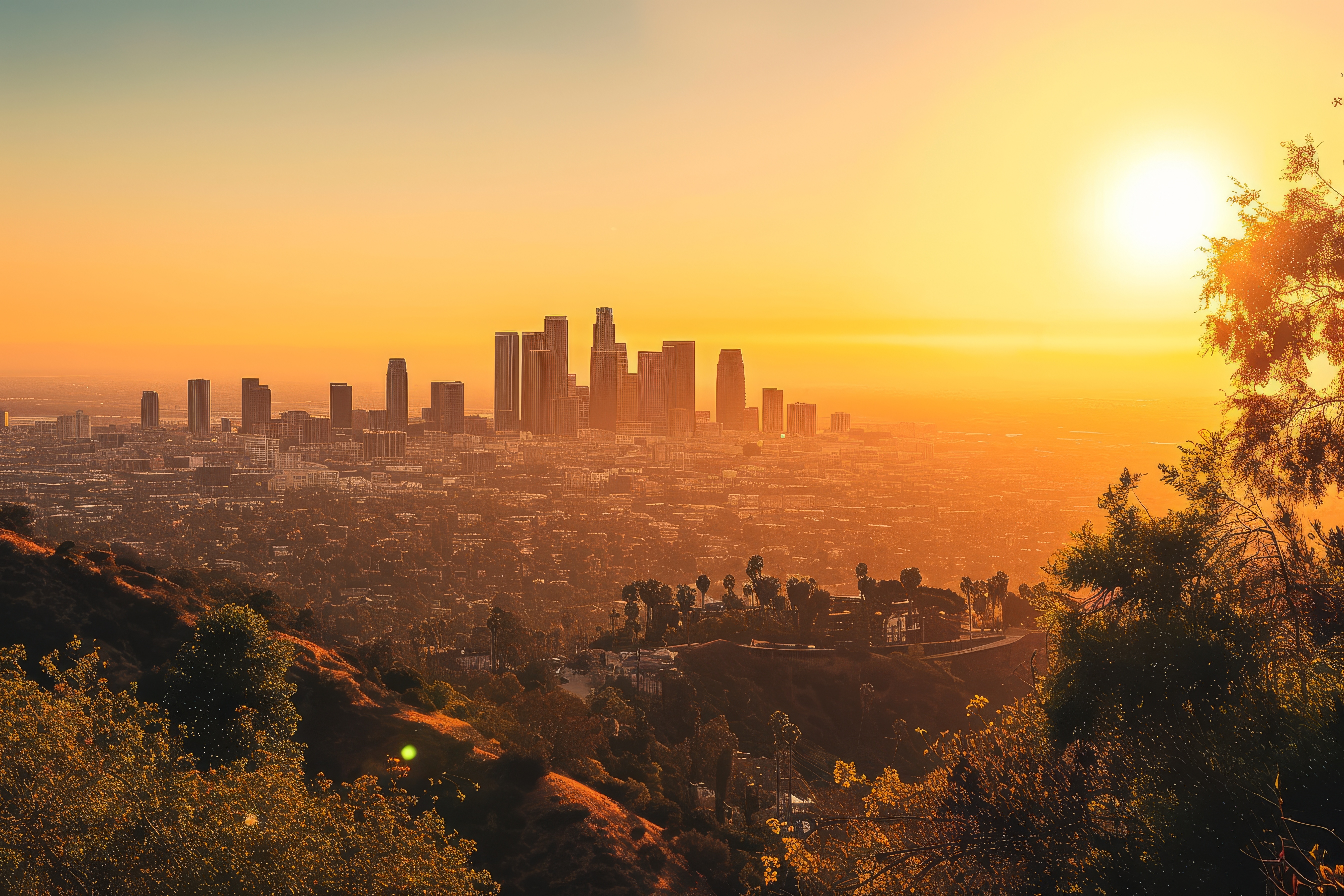An aerial view of a city landscape with skyscrapers and some scattered greenery around during the sunset.