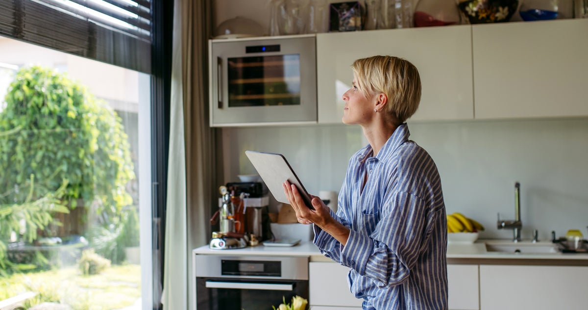 woman closing metal blinds on smart home automation system.