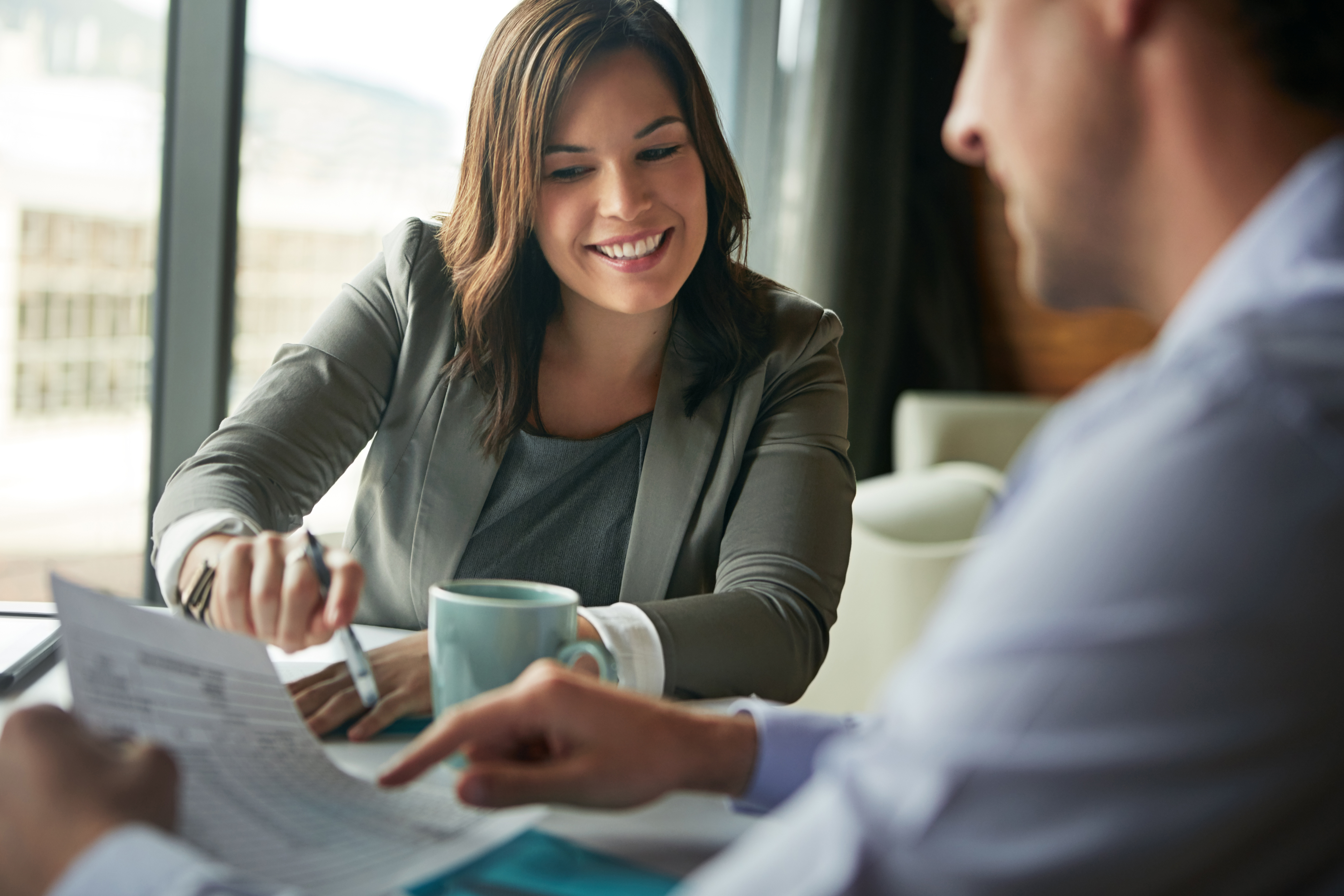 A woman is seen smiling while looking at documents.