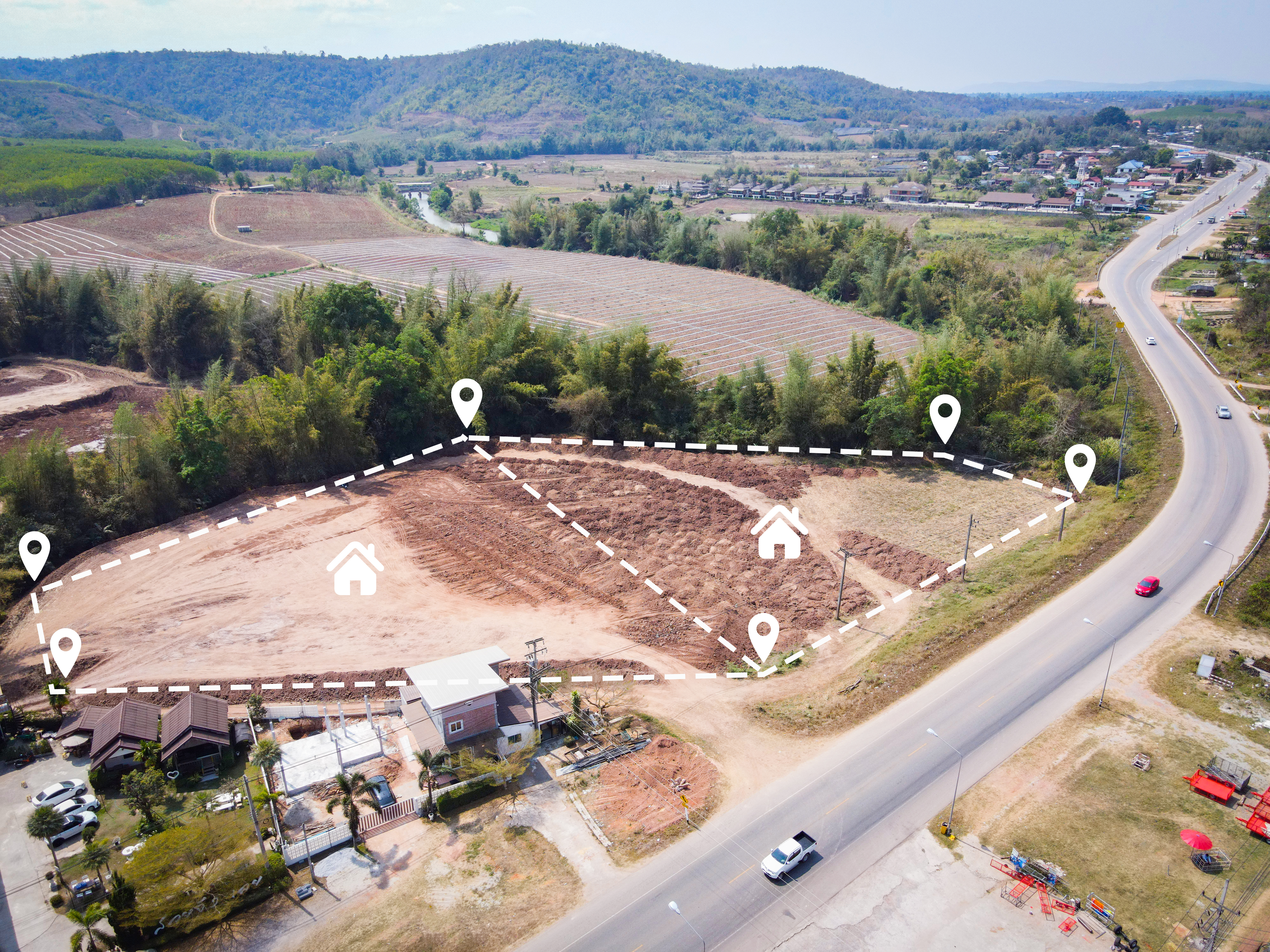 An aerial view of a vacant land plot marked for housing development. 