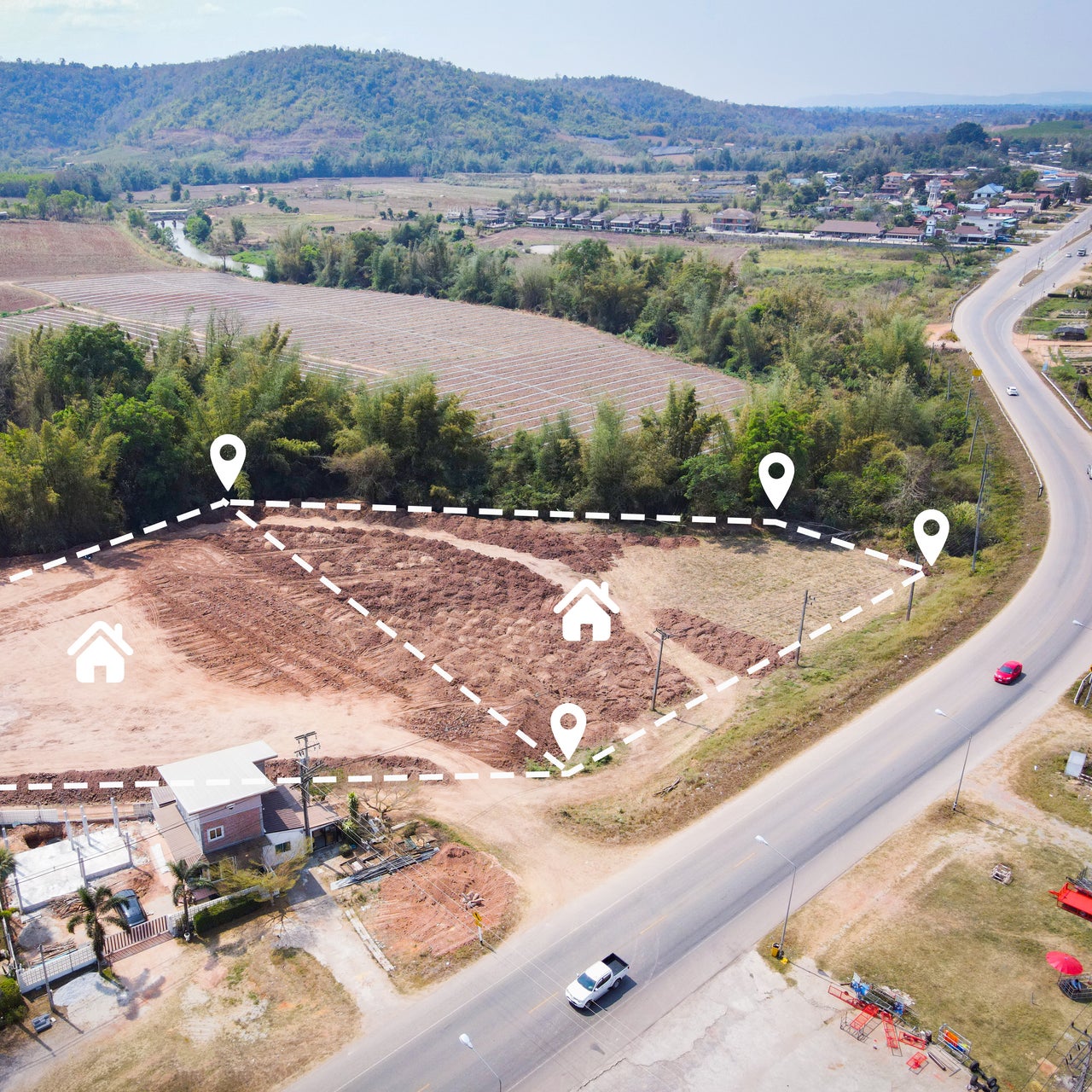 An aerial view of a vacant land plot marked for housing development.