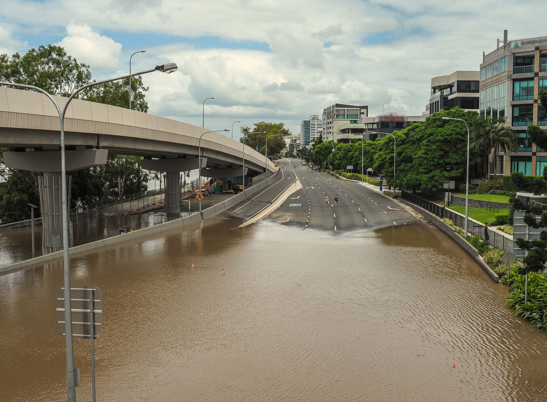 Person walking away from a flooded highway