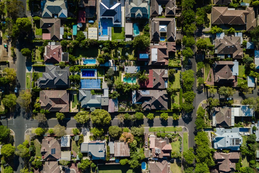 Aerial view of a suburban neighborhood with houses, backyards and pools.