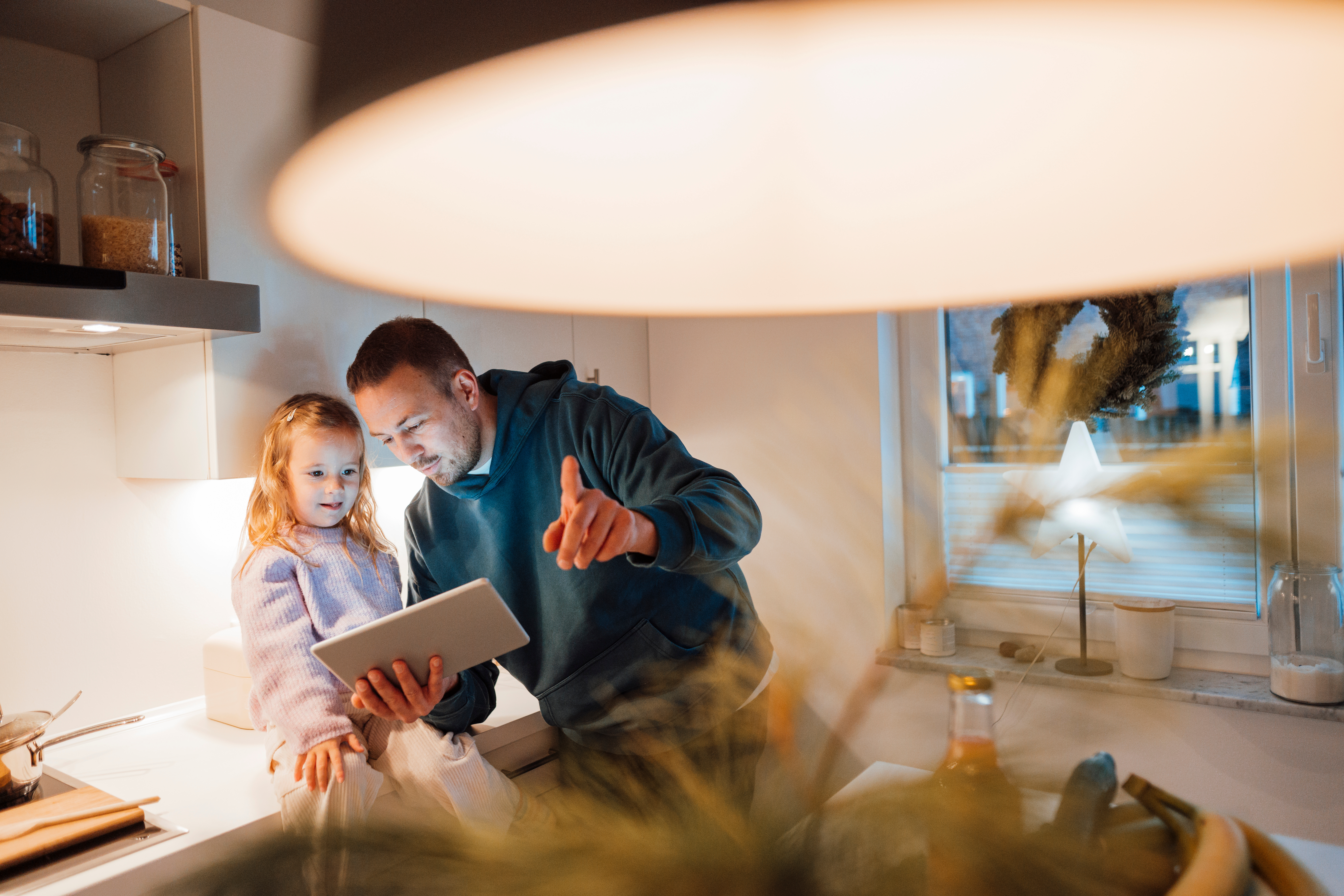 Father and daughter looking at smart pad tablet