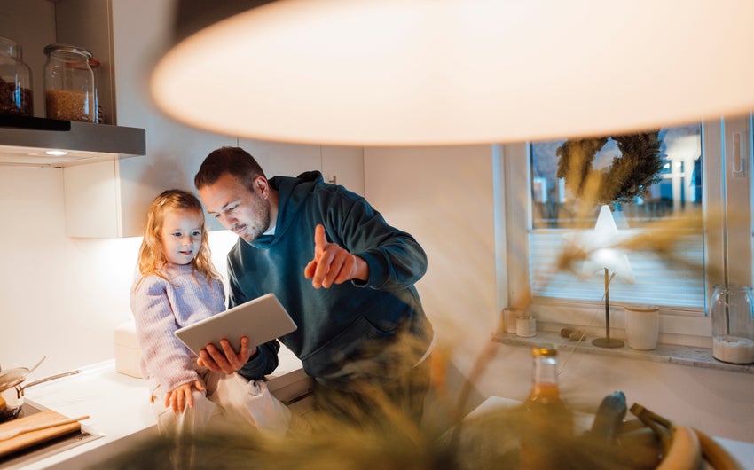 Father and daughter looking at smart pad tablet