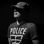 Black and white image of FC standing with a baseball cap and t-shirt with the word Police on the front.