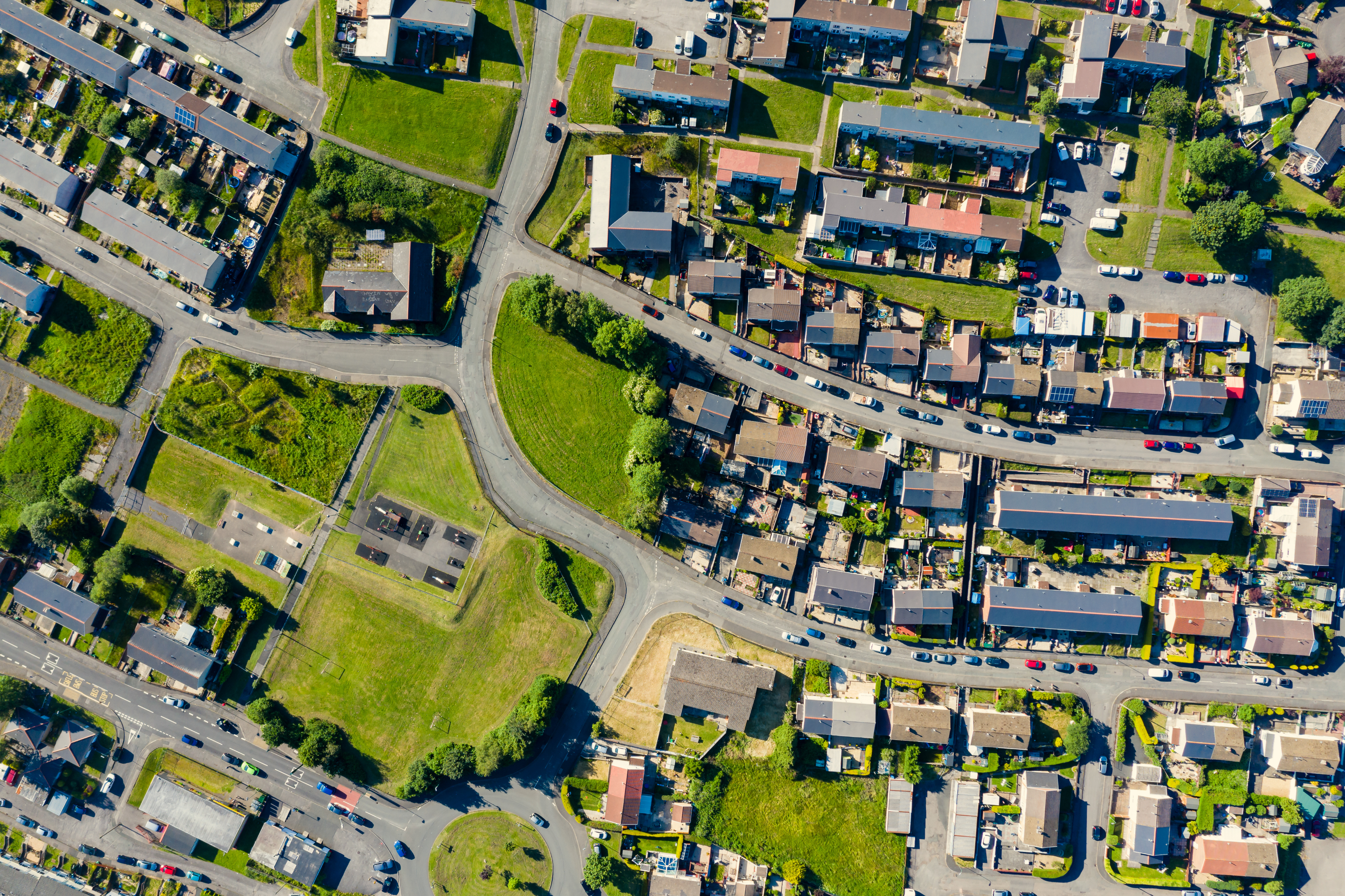 An aerial view of a well planned residential neighborhood with bunch of houses and greenery around.