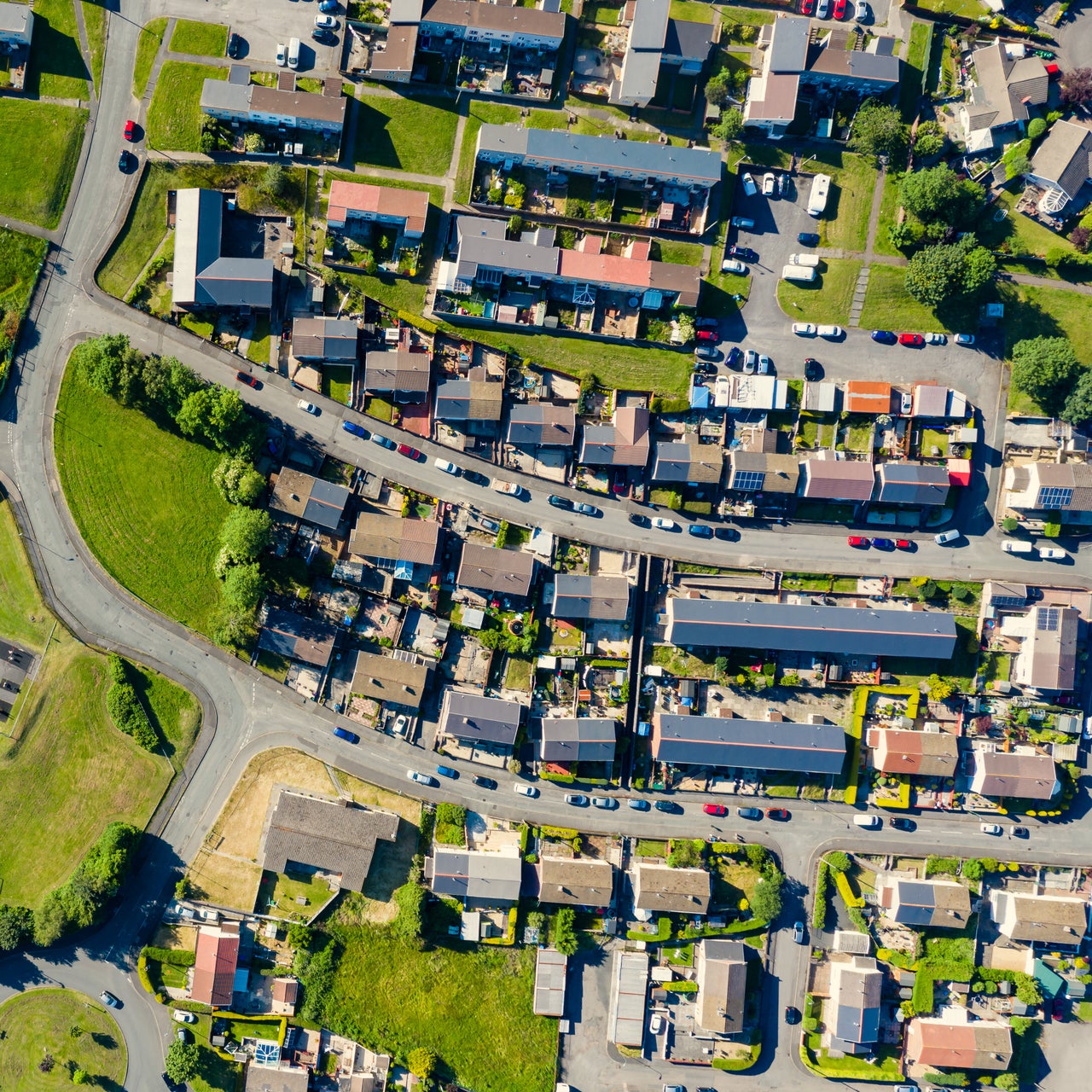An aerial view of a well planned residential neighborhood with bunch of houses and greenery around.